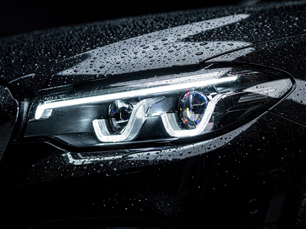 Detail van de koplamp van een donkere premium sedan